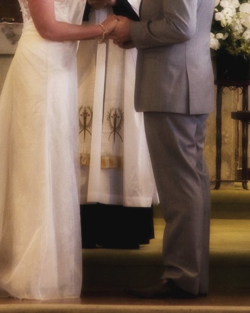 A couple holding hands at the altar